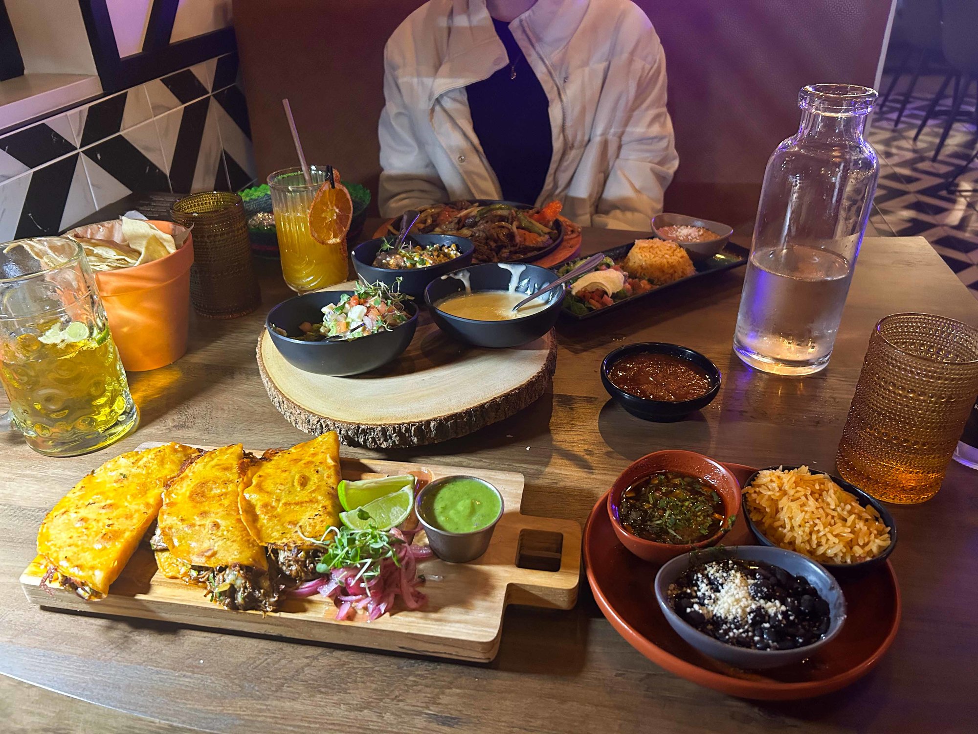 spread of mexican food on a table with drinks